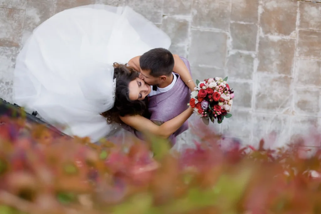 top view beautiful wedding couple with wedding bouquet who are kissing outdoors marriage concept